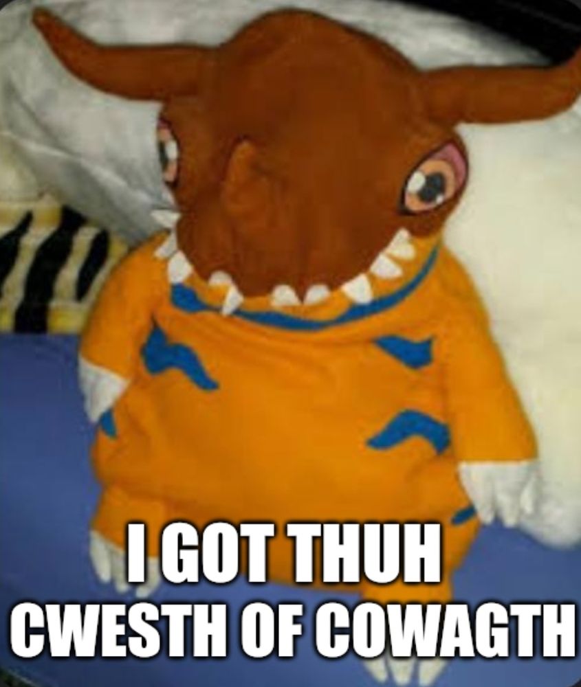 A picture of really derpy plush of Greymon with its scraggly teeth hanging out everywhere. The caption reads, "I got thuh cwesth of cowagth" (I got the crest of courage)