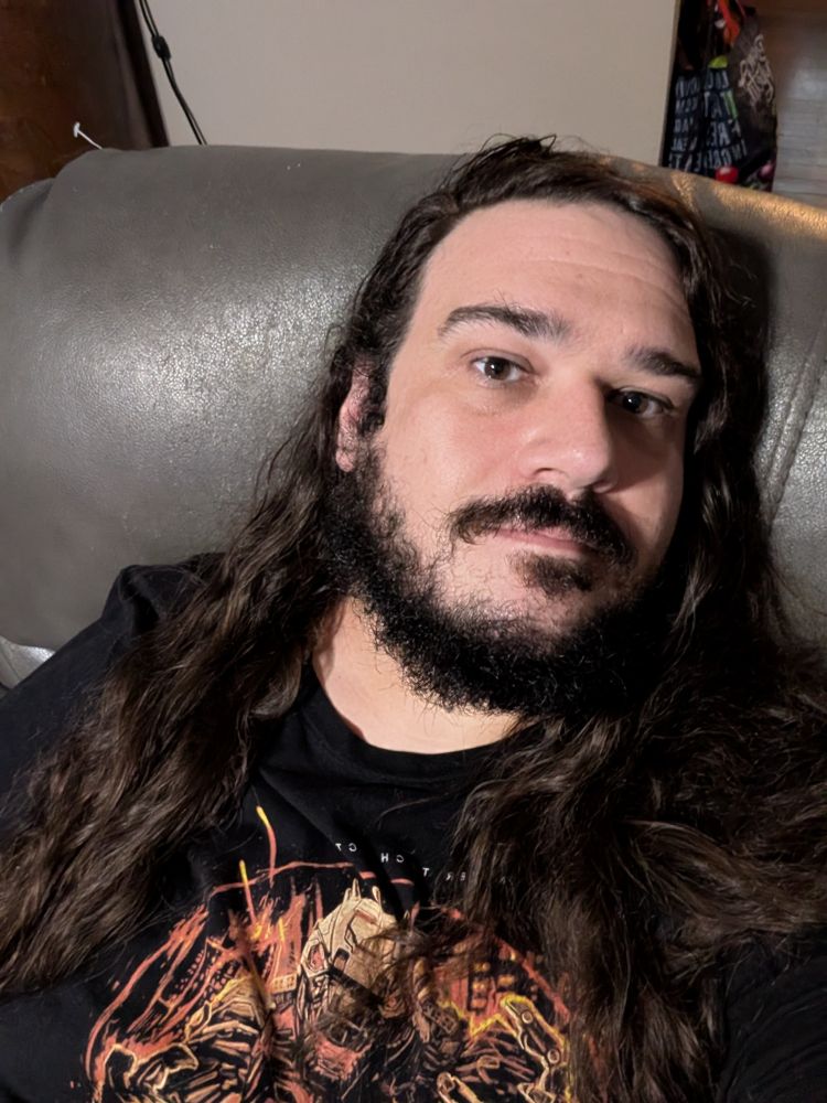 A long haired, bearded man wearing all black