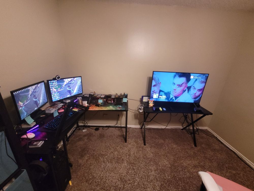 Angle 1 of new media room setup, showing two monitors, a PC, a tv, two desks and a Nintendo Switch