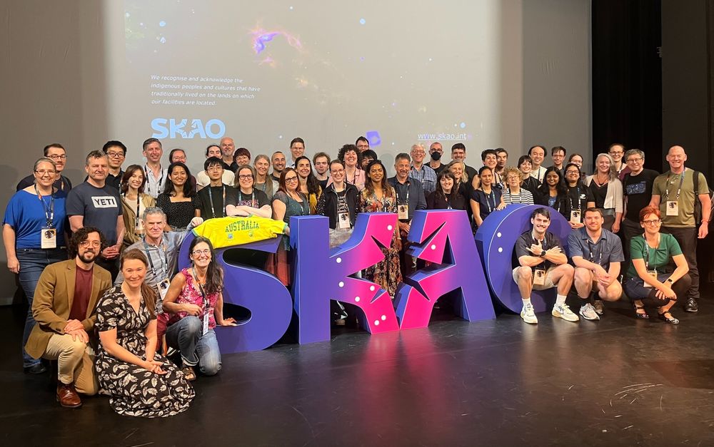 Picture of a large group of Australian radio astronomers on the stage at the SKAO 2025 meeting. 