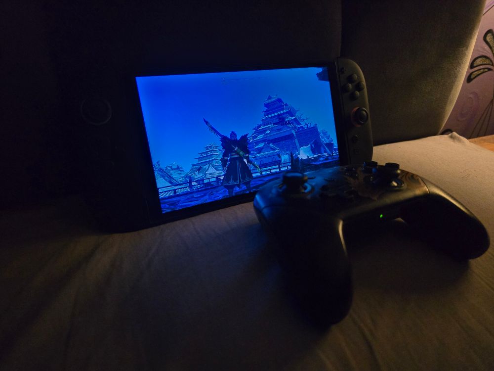 A switch 2 with a switch 1 pro controller on a bed