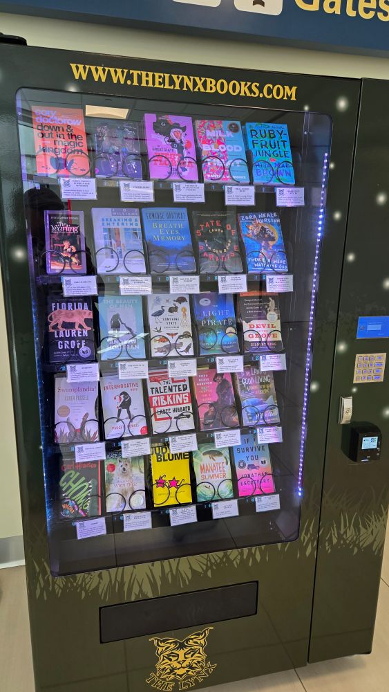 A spread of many colored book covers displayed in a vending machine. The machine had a label that reads "www.thelynxbooks.com"
