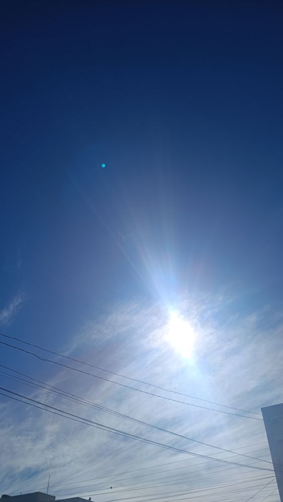 Um céu azul com nuvens e sol, surpreendentemente