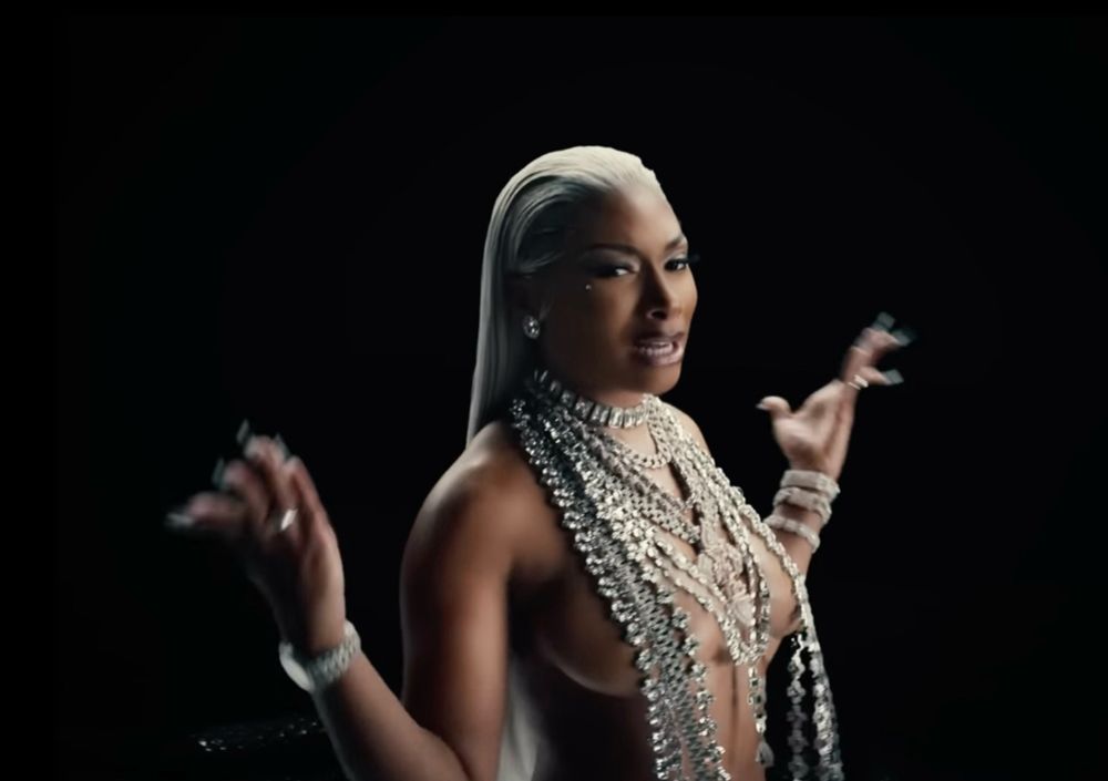 megan in her tina snow look (platinum blonde hair slicked back, big silver necklace down her chest