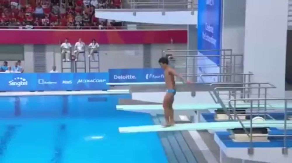 a man is diving into a pool with a sign that says deloitte