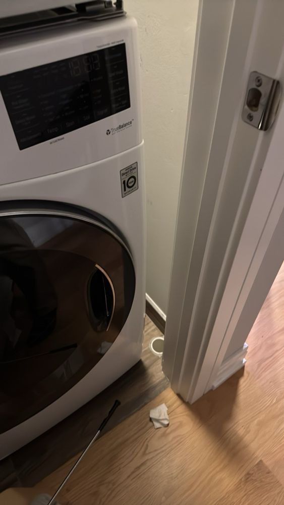 A catch drain behind a 3 inch gap between the door frame and a washing machine