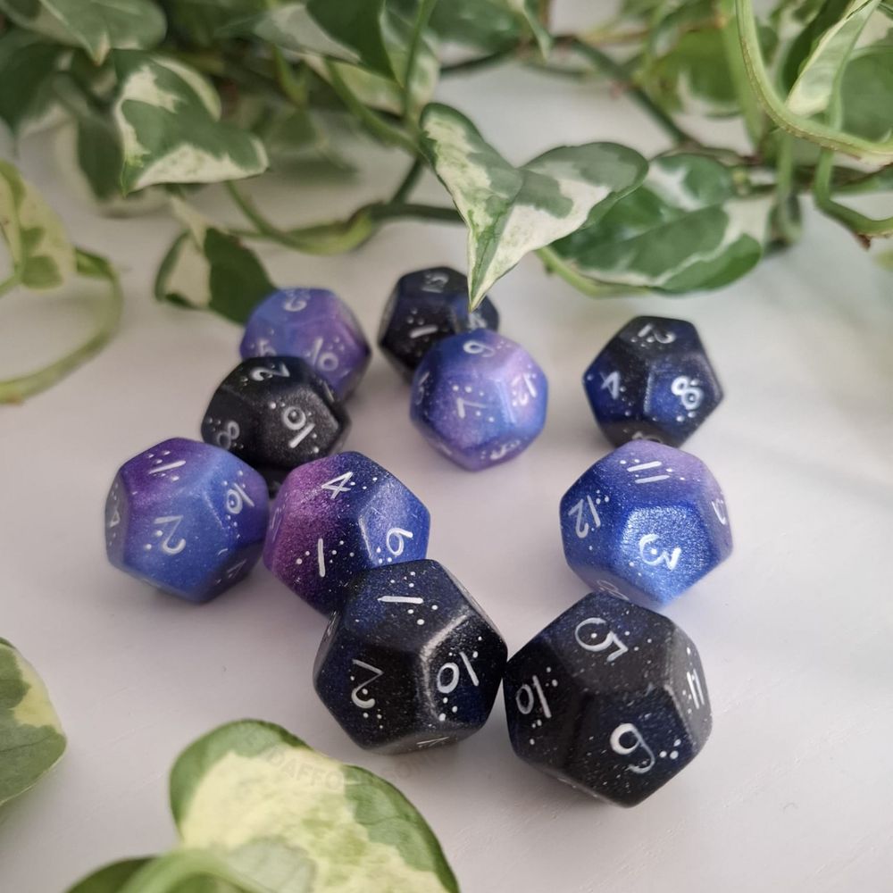 hand-painted d12 duality dice. half of them are painted in a galaxy style, the other half in starry night style