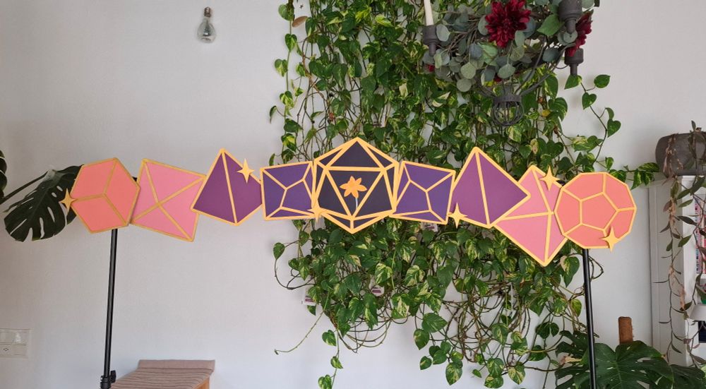 Convention display that will go up above my booth. It is a d20 with my logo in the middle, and then a gradient to both sides: d10, d4, d8 and then a d12 on the right and a d6 on the left