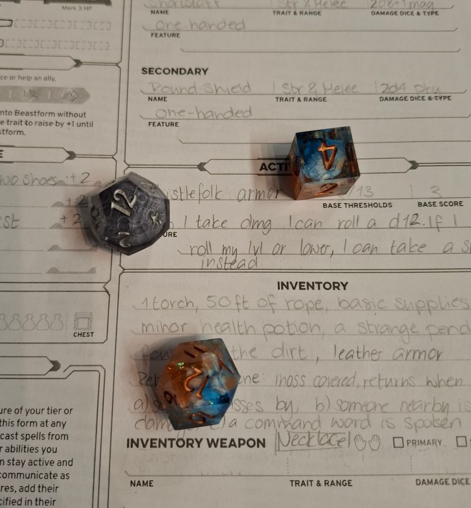 3 dice on top of a daggerheart character sheet. I rolled a crit on the d12 with the number 12 and a 4 on the advantage d6