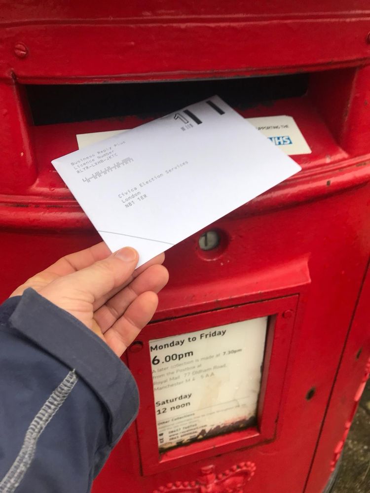 Posting a ballot envelope in a postbox