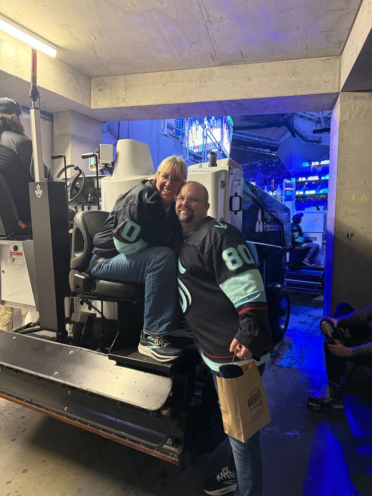 My boyfriend & me in the tunnel before I went out on the ice. I am sitting on the Zamboni & he is standing next to me