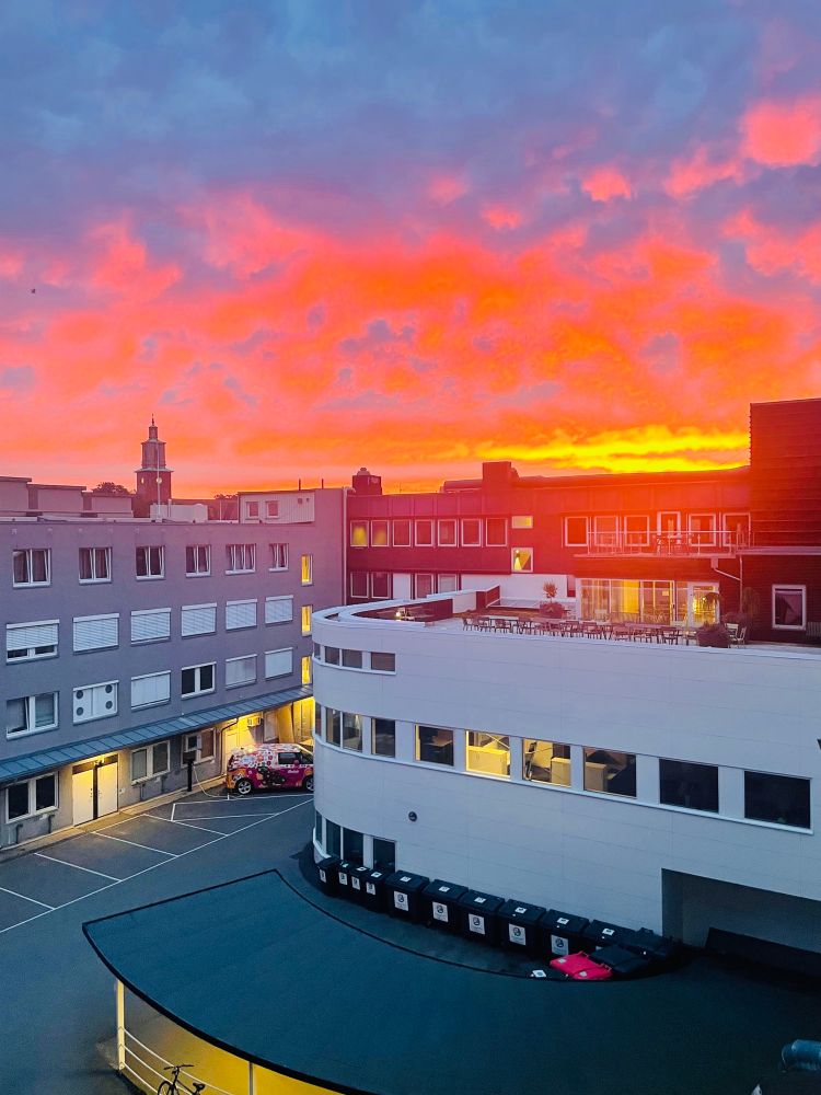 Soloppgang over bygning. Oransje, som en brann.