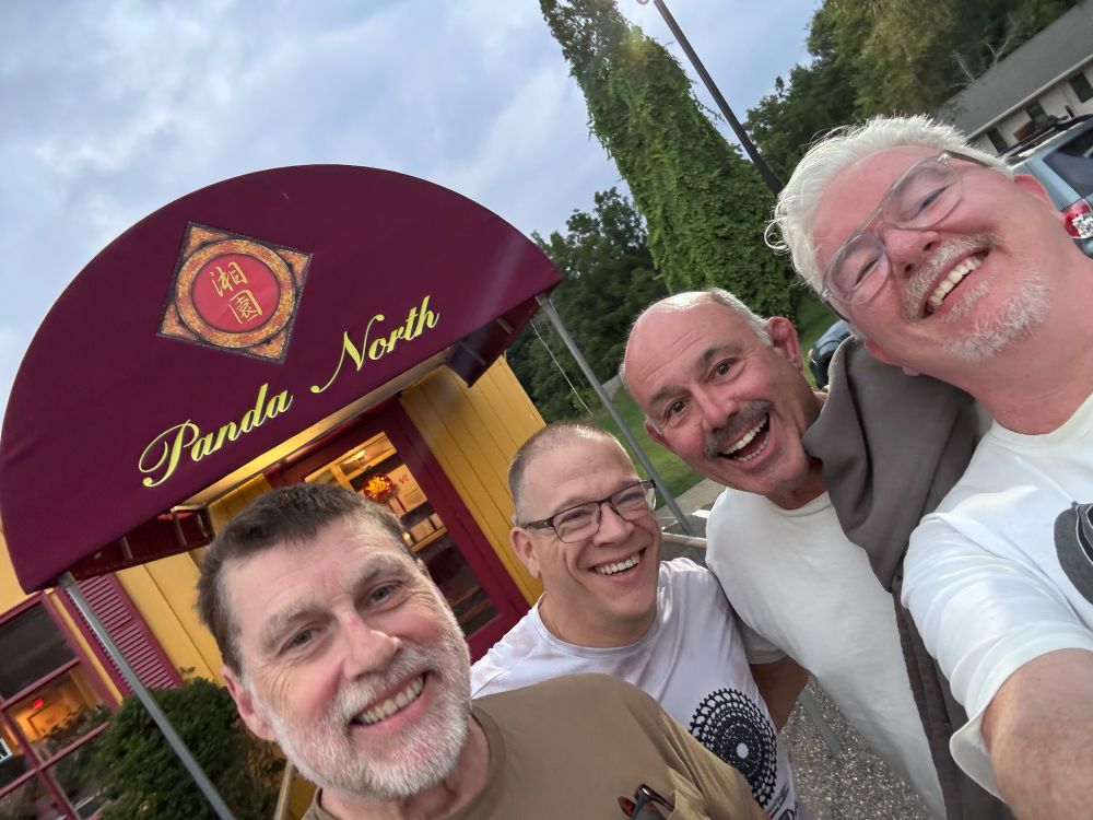 four men smiling in a selfie 