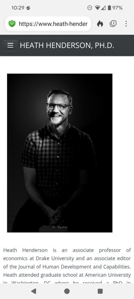 A picture of an incel looking white man in a stylized black and white photo. His checked shirt is tight showing off his biceps