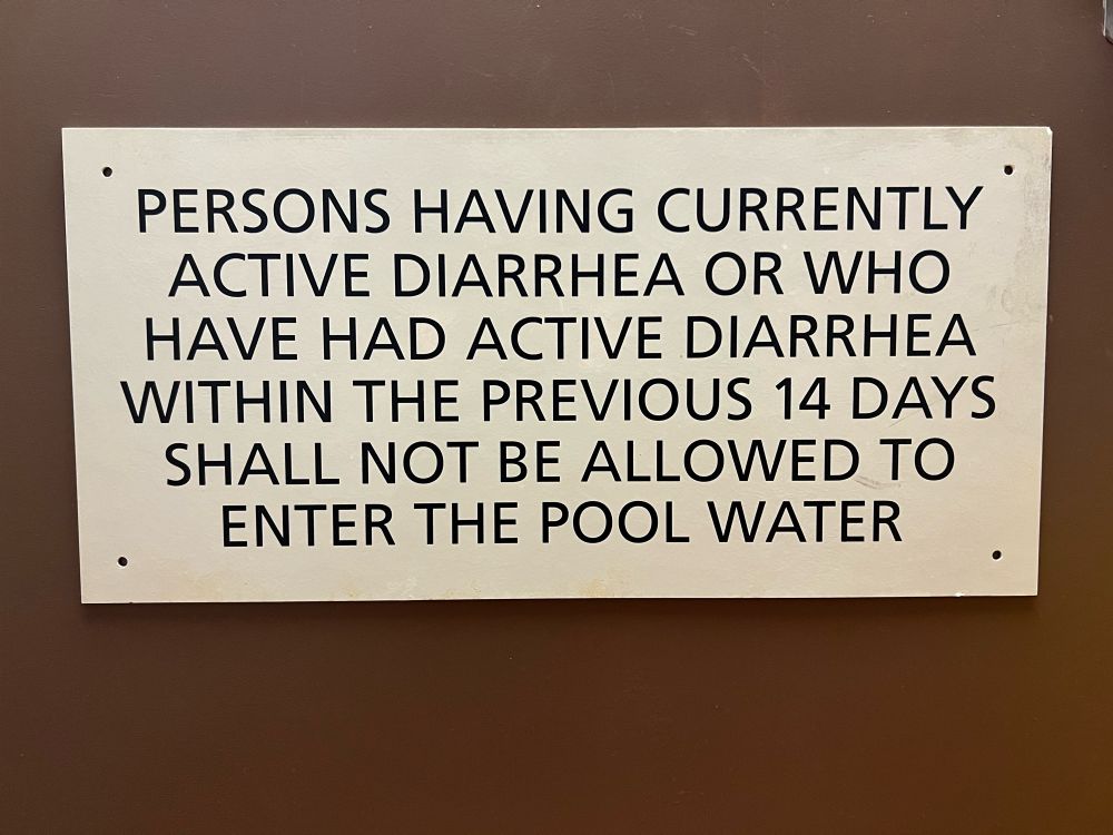 A sign, reading in all capital letters:

PERSONS HAVING CURRENTLY ACTIVE DIARRHEA OR WHO HAVE HAD ACTIVE DIARRHEA WITHIN THE PREVIOUS 14 DAYS SHALL NOT BE ALLOWED TO ENTER THE POOL WATER