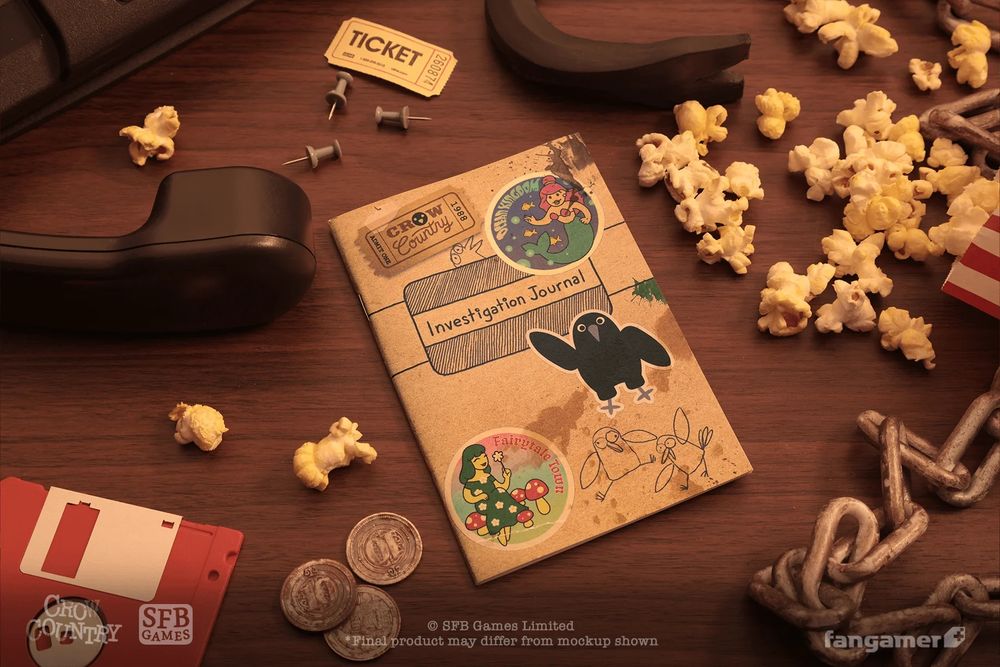 A photo of the Investigation Journal in the Crow Country Deluxe Edition on a 90s-style desk set. A phone handset, a floppy disk, a ticket, and some popcorn are visible surrounding it. The journal appears to be covered in stickers.