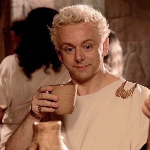 Aziraphale holding a cup while looking somewhat surprised (no)