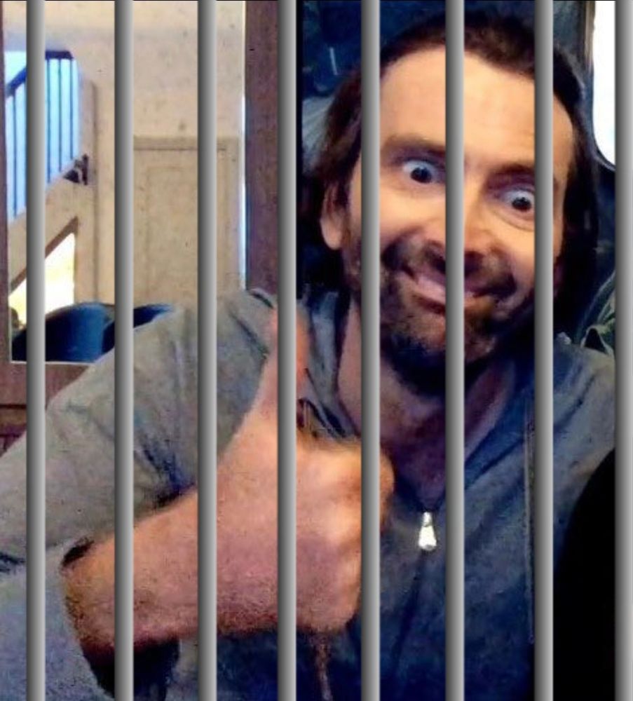 David Tennant giving a thumbs up qhile jailed