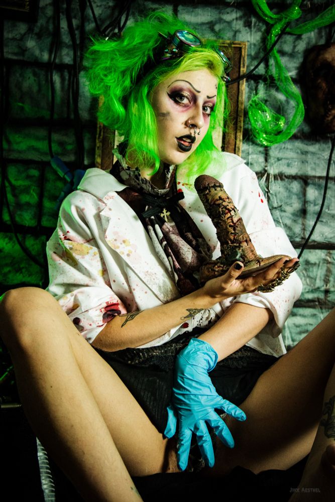 Jinx Aesthel dressed as a mad scientist and holding the frankencock by monster cocks