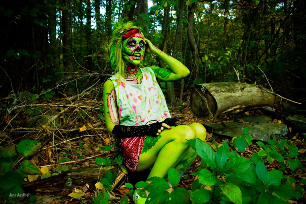 Jinx Aesthel out in the woods in their pop art neon zombie bodypaint photoshoot
