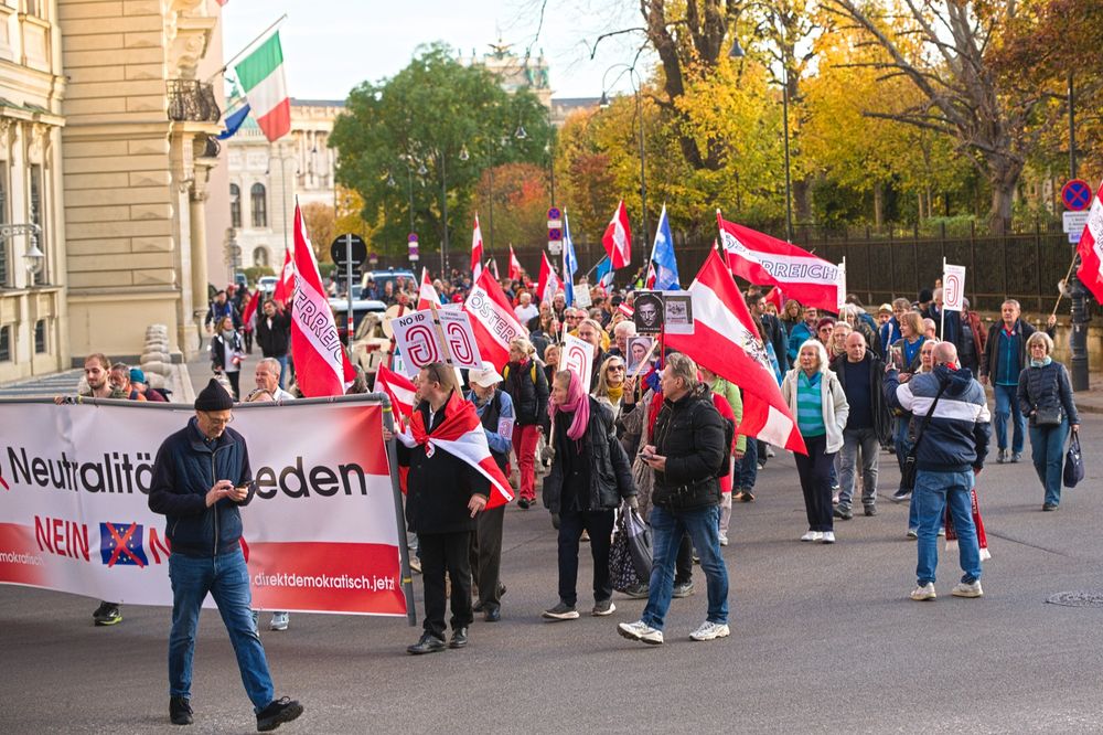 Demonstrationszug vor dem Burgtheater, zahlreiche Österreich-Flaggen zieren die Menge.
