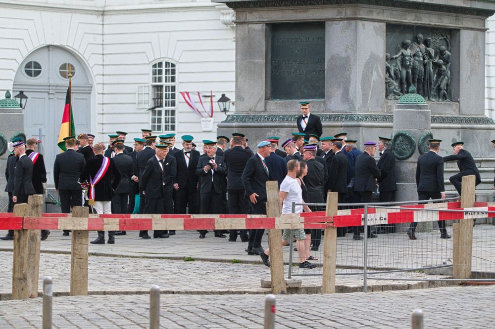 Alte Herren und Burschen der Libertas nehmen am Josefsplatz Formation an und posieren mit Deutschland- und Burschenschaftsflagge für ein Foto. In der Mitte Nationalratspräseident Walter Rosenkranz.