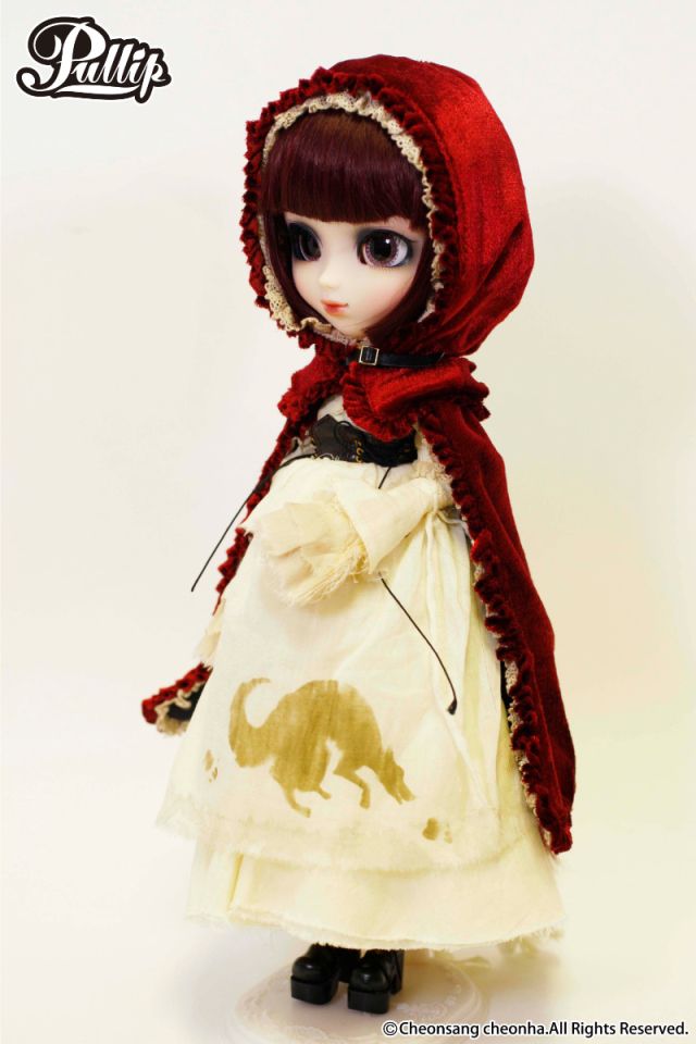 A full body shot of the same doll. She has a golden wolf silhouette stitched on her apron and little black boots