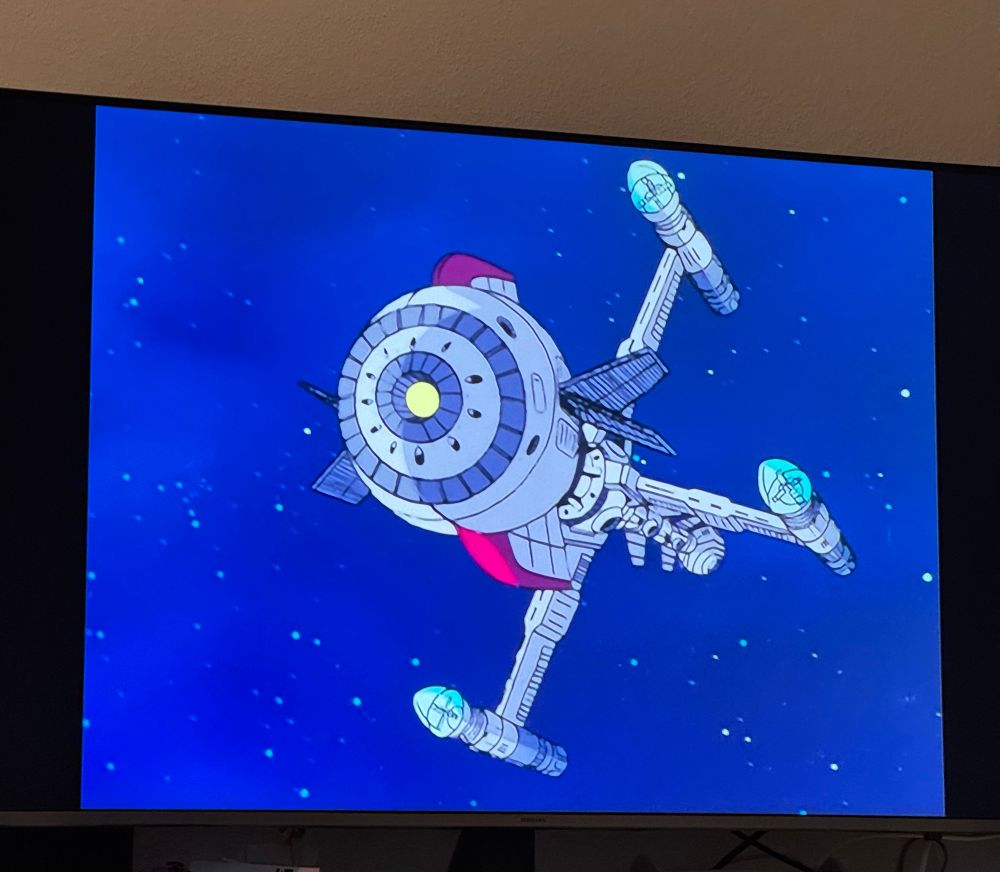 Man sieht einen Fernseher auf dem ein Bild einer Zeichentrickserie erkennbar ist. Es handelt sich bei dem Bild um das Raumschiff Comet von Captain Future