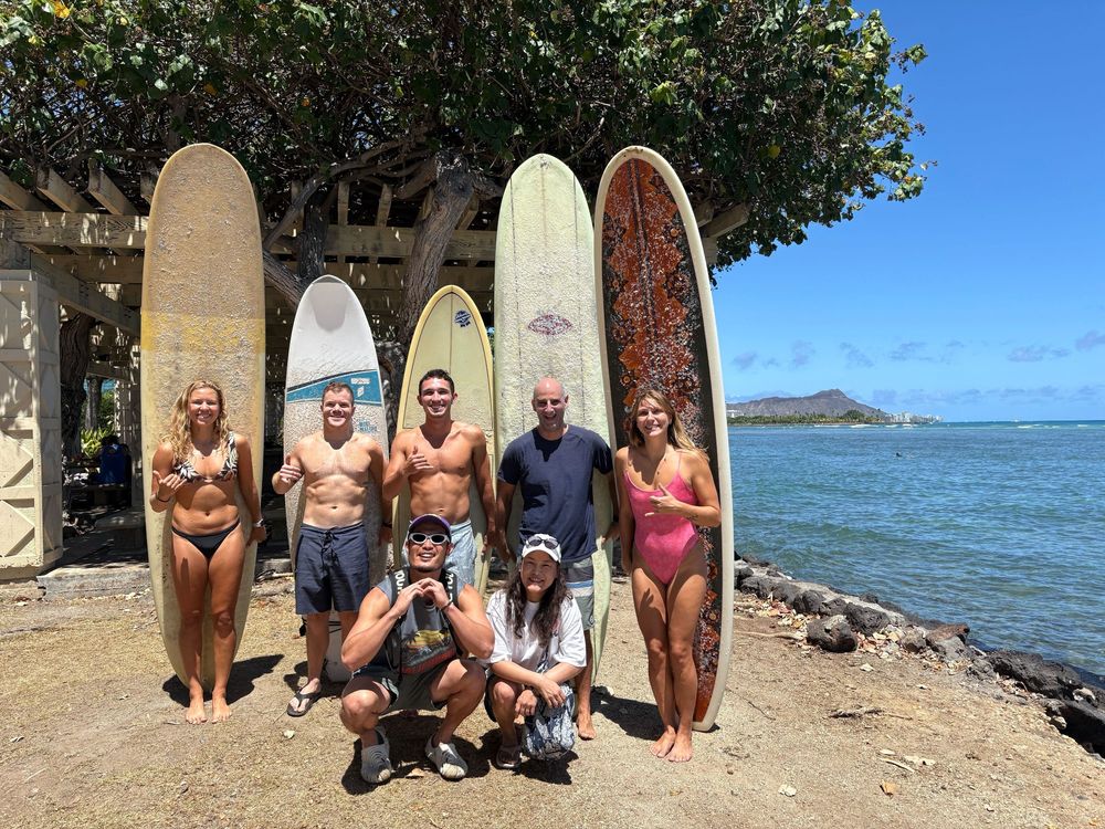 Our lab group posing with surfboards in front of diamondhead volcano