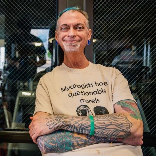 A picture of Tom Volk wearing a tshirt that says Mycologists have questionable morels.