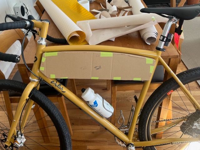 a cardboard mockup of a frame bag on a bicycle