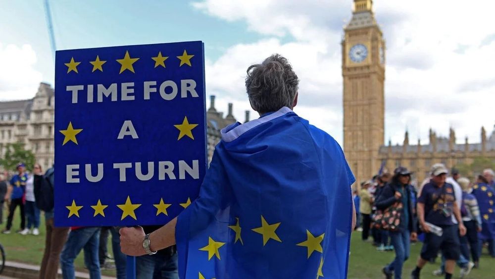 Protesters gather outside the UK Parliament in London in March, rallying against Brexit with banners and signs.