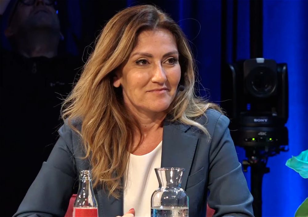 Dilan Yesligöz toen ze nof minister van Justitie was. Ze draagt een blauw jasje met iets wit eronder. 