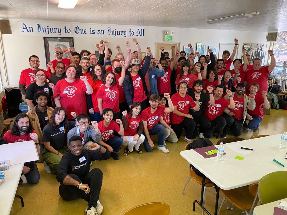 a photo of a big group of Alphabet Workers Union members on the West Coast wearing their red union tshirts and raising their fists.