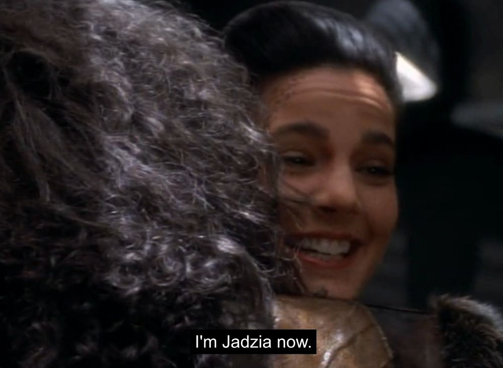 A screenshot from Star Trek Deep Space Nine of a Klingon named Kor hugging Jadzia Dax, and her saying, "I'm Jadzia now"