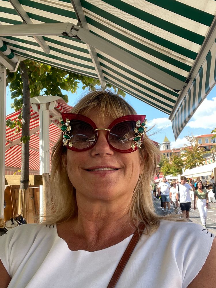 Woman trying sunglasses at an antique market 