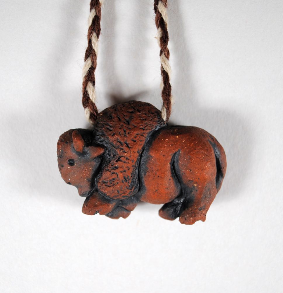 image of a red clay bison pendant suspended on a necklace cord, right side