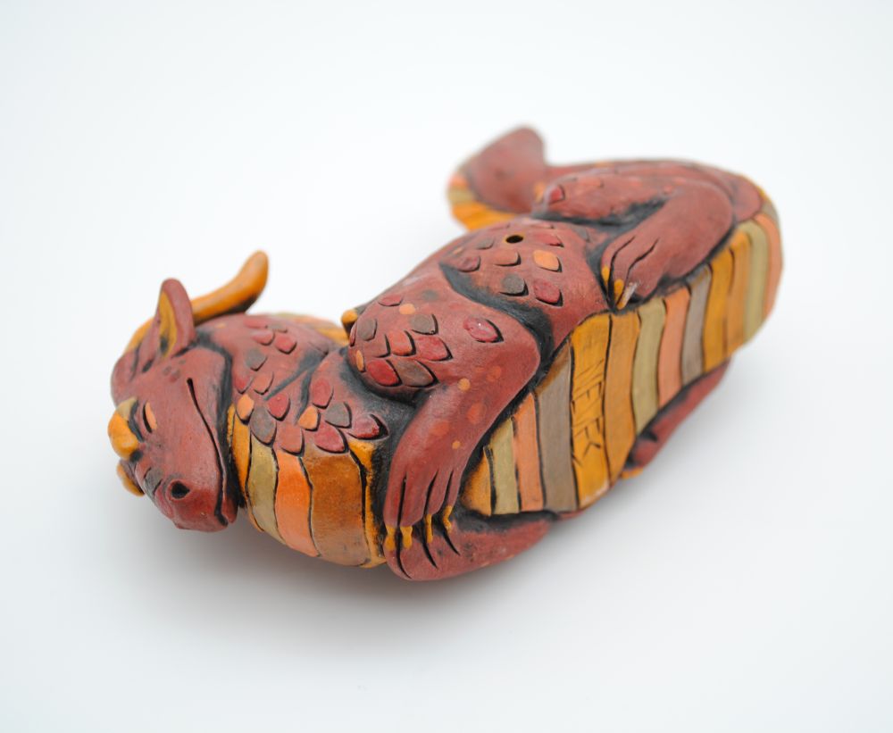 photo of the underside of the pipe showing the belly scale patterns and cutely tucked front paws of the dragon