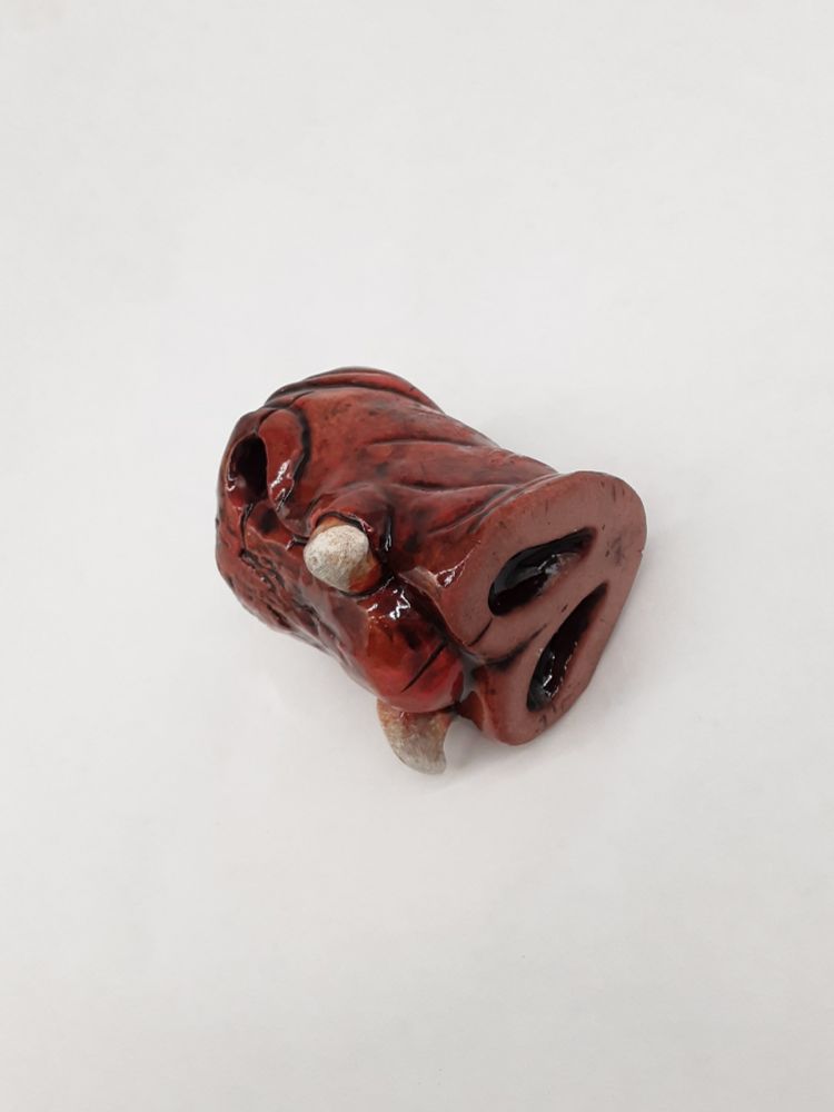 white background photo showing a ceramic shot glass in the shape of a tusked pig snout