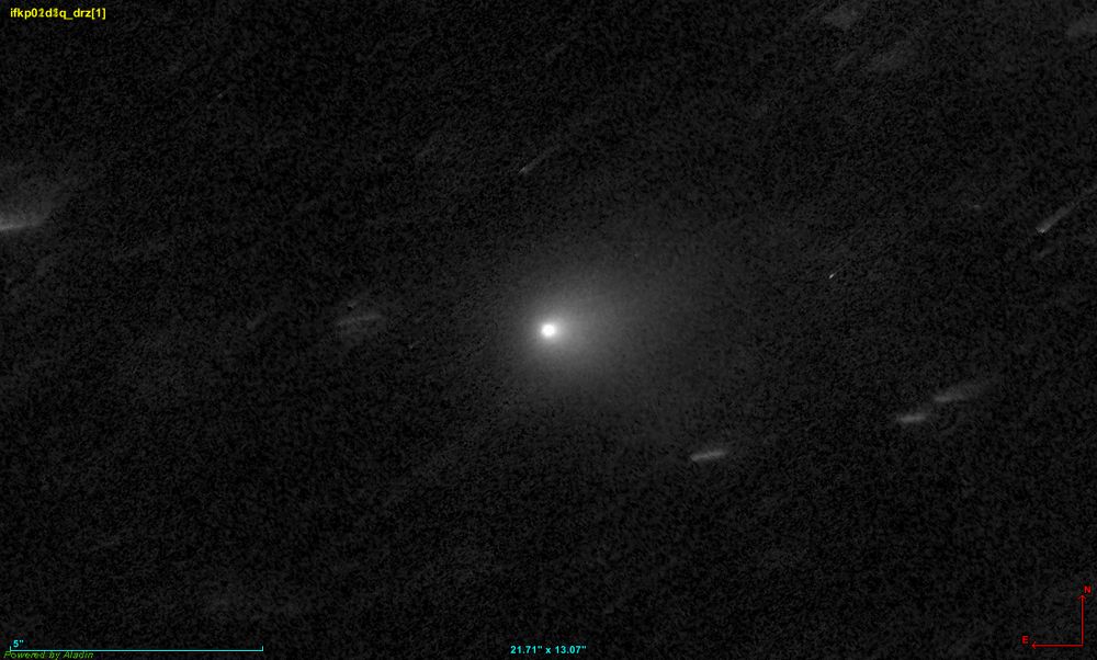 3I/ATLAS (big gray fuzzy blob at center) as seen by the Hubble Space Telescope. This image was created by combining 4 Hubble images with median blending. This isolates the comet from the background stars and noise.