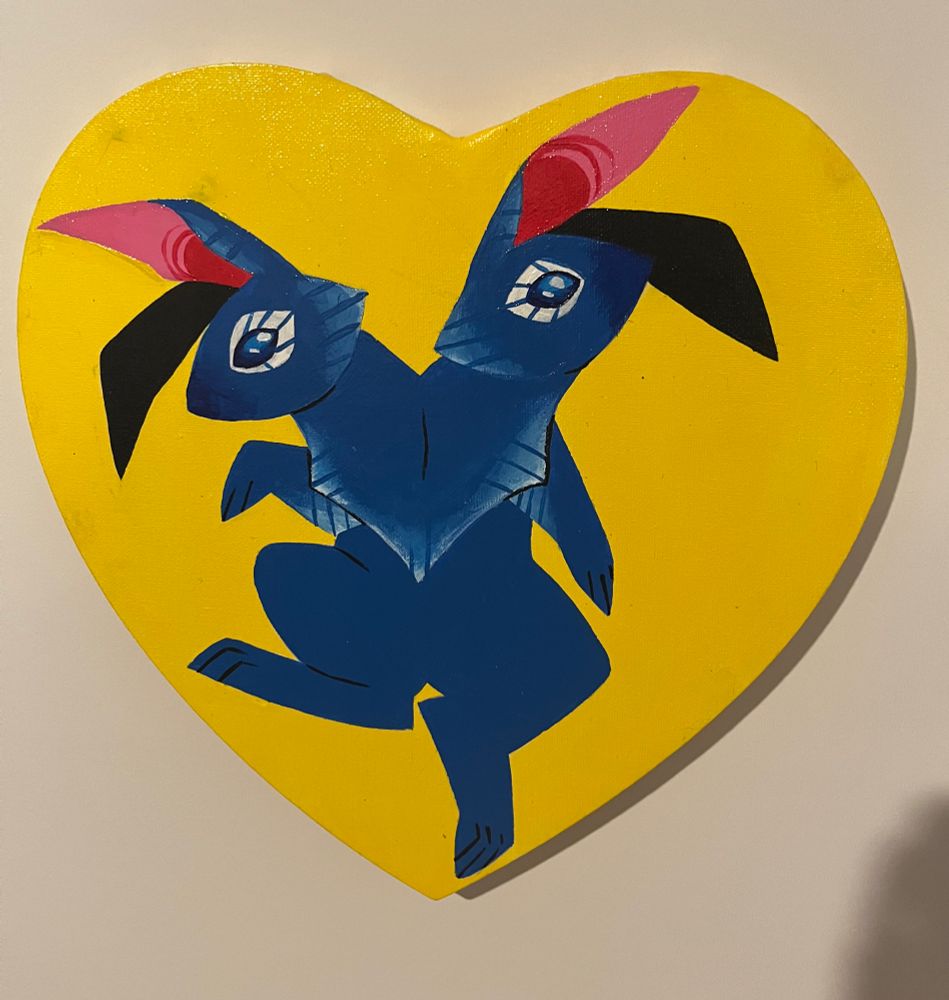 heart shaped canvas painted primary yellow with a two headed dark blue rabbit 