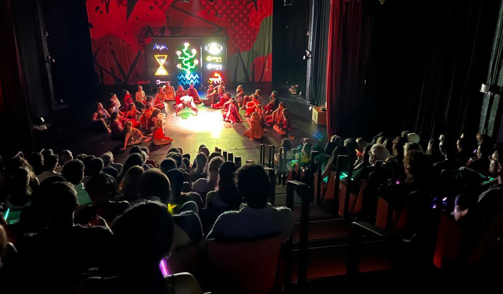 A full theater watching a dance performance.