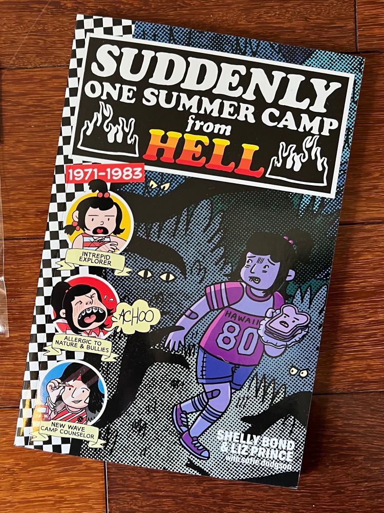 The comic Suddenly One Summer Camp From Hell on the floor. Next to it is a bag of stickers.