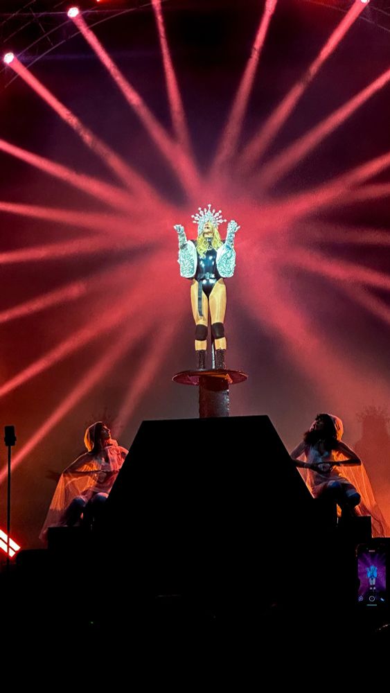Kesha the pop star singer on a platform with lights beaming on her during a performance 