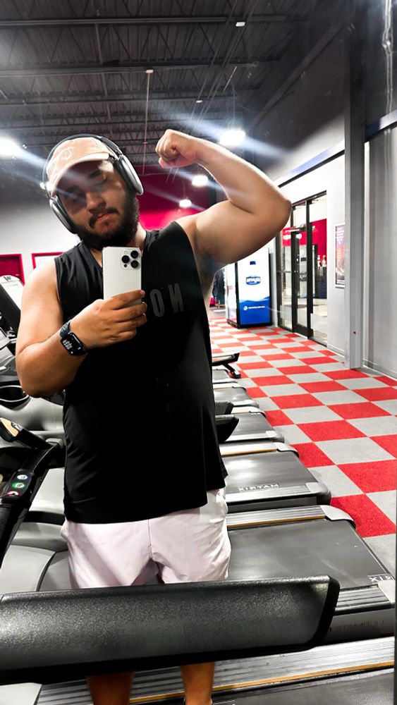 Man flexing bicep in gym