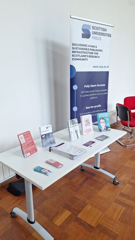 A photograph of SUP's display table at the UWS Research Festival including flyers, bookmarks and three of SUP's book on stands.