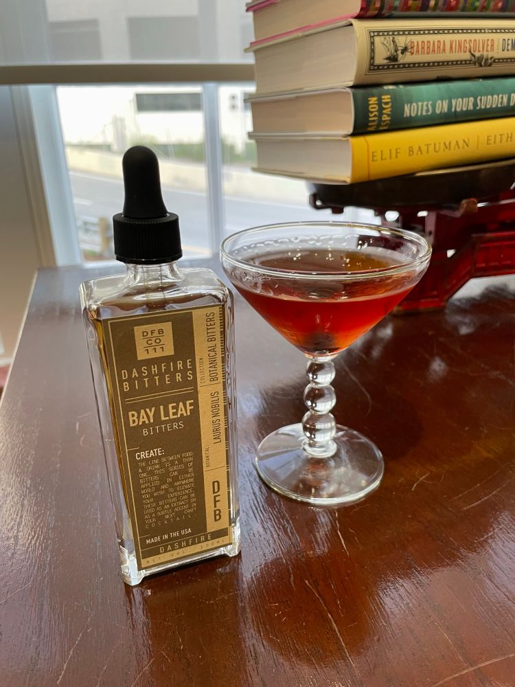 A bottle of bay leaf bitters next to. Manhattan in a vintage glass with a candlewick stem. Two dashes of angostura’s and two dashes of bay leaf in my regular recipe tastes like fall.