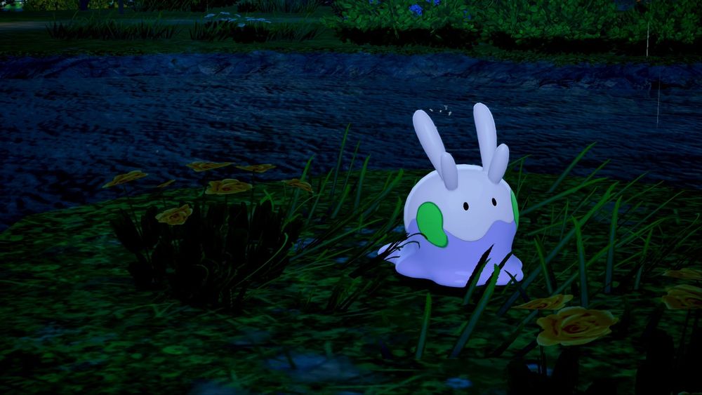 In-game photo of the Pokemon Goomy. It's just hanging out in the grass while it rains at night.