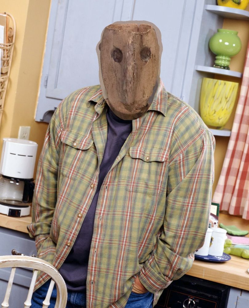 Kevin James with hands in pockets meme, but his face is replaced by that of Levant Chalcolithic male figurine, 4500-3500 BC