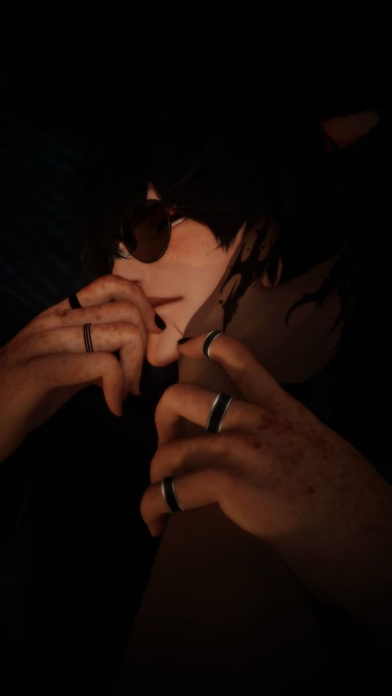 imagine of a man with jet black hair, sunglasses, freckled face and a scar on his chin laying down. he has a hand somewhat covering his mouth, with another hand reaching off screen to hold his face. he's grabbing the wrist of the other.